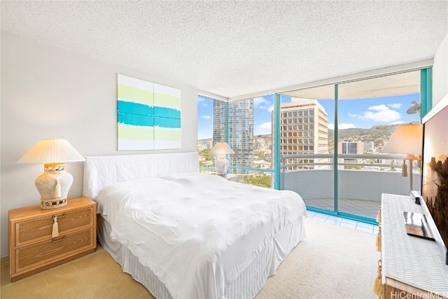 carpeted bedroom with access to outside, a textured ceiling, and floor to ceiling windows