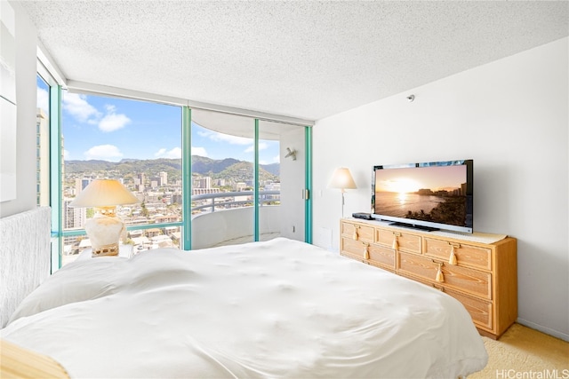 carpeted bedroom with a textured ceiling, multiple windows, access to exterior, and floor to ceiling windows