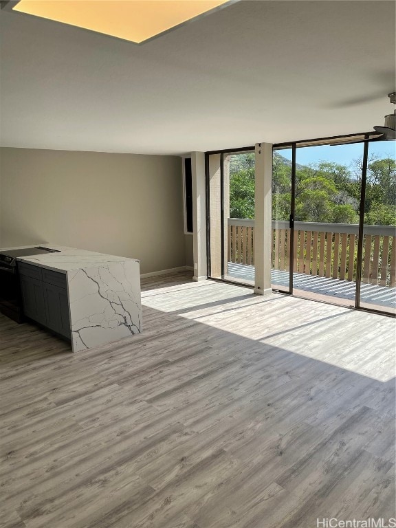 unfurnished living room with expansive windows and light hardwood / wood-style flooring