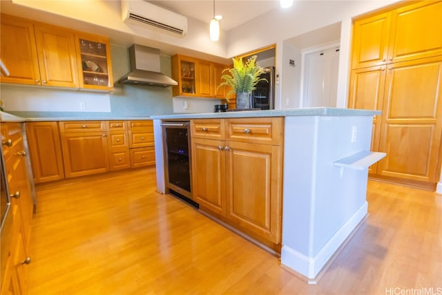 kitchen with wall chimney range hood, wine cooler, light hardwood / wood-style flooring, an AC wall unit, and pendant lighting