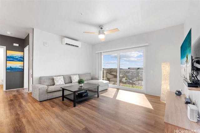 living room with an AC wall unit, light wood-type flooring, and ceiling fan