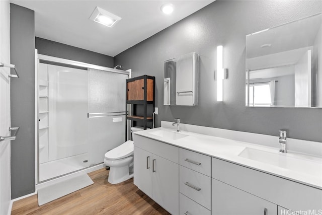 bathroom with vanity, hardwood / wood-style flooring, toilet, and an enclosed shower