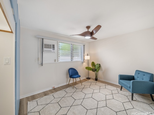 unfurnished room with light wood-type flooring, an AC wall unit, and ceiling fan