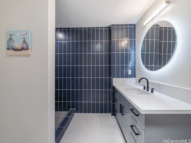 bathroom with vanity, tile walls, and walk in shower