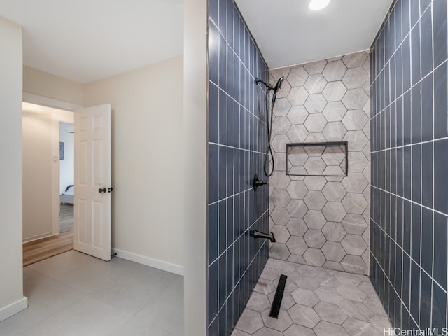 bathroom featuring tile patterned flooring, a shower, and tile walls