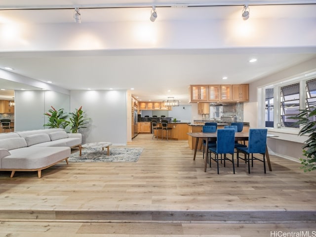 dining room with track lighting and light wood-type flooring