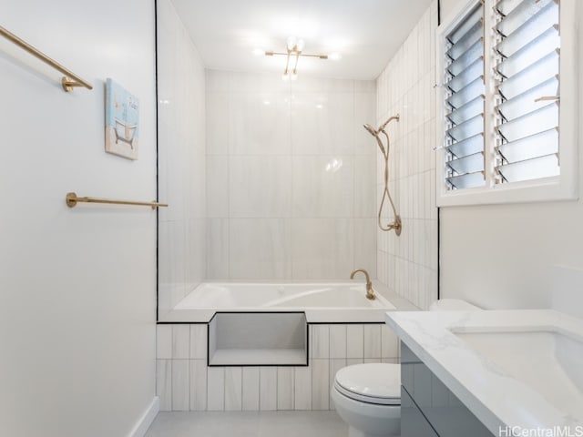 full bathroom featuring tile patterned floors, tiled shower / bath combo, toilet, and vanity