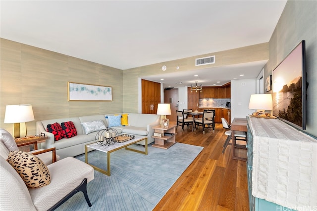 living room with an inviting chandelier and dark hardwood / wood-style flooring