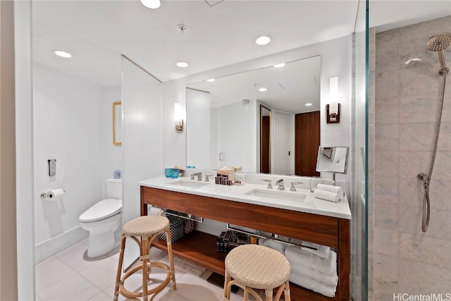 bathroom with vanity, toilet, tile patterned floors, and tiled shower