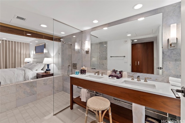 bathroom with a tile shower, tile walls, tile patterned flooring, and vanity