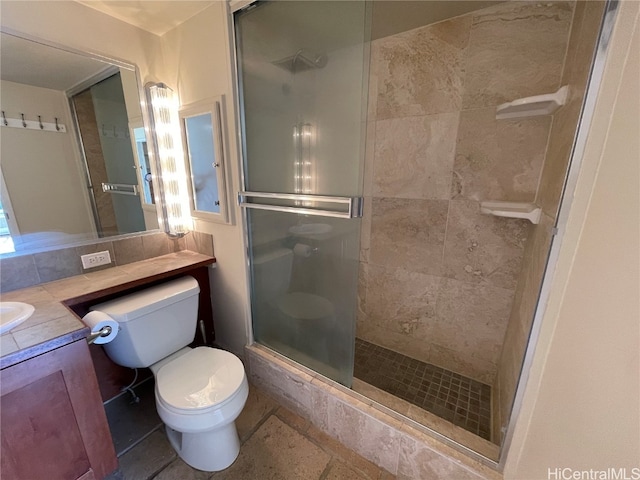 bathroom featuring vanity, toilet, and a shower with door