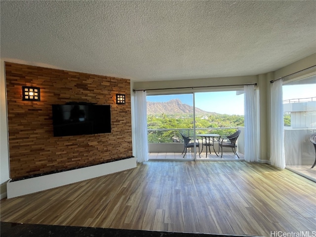 unfurnished living room featuring a textured ceiling and hardwood / wood-style flooring