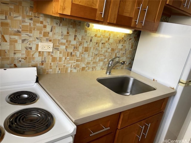 kitchen featuring range, tasteful backsplash, and sink