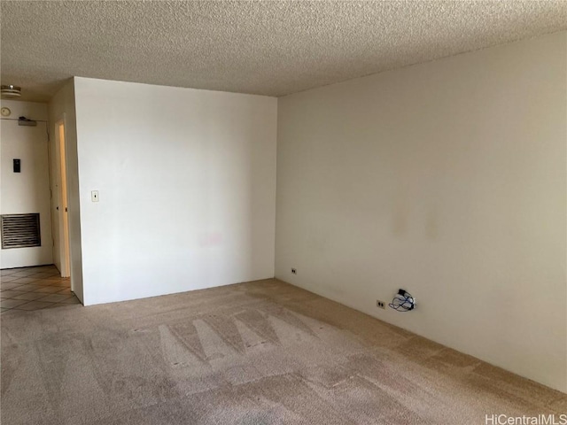 carpeted empty room with a textured ceiling