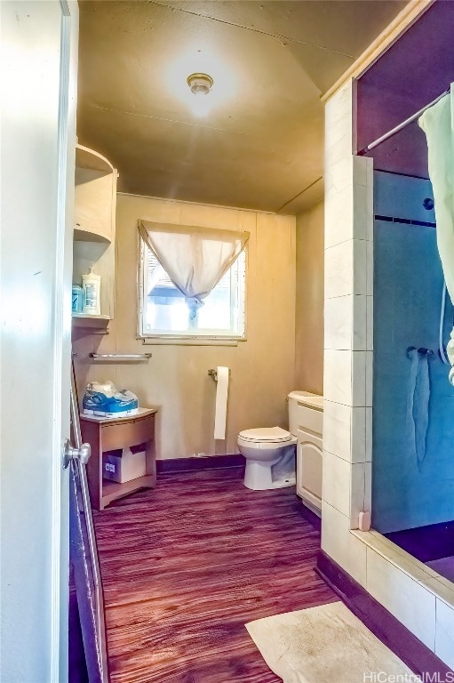 bathroom featuring toilet, hardwood / wood-style flooring, and a shower with shower curtain