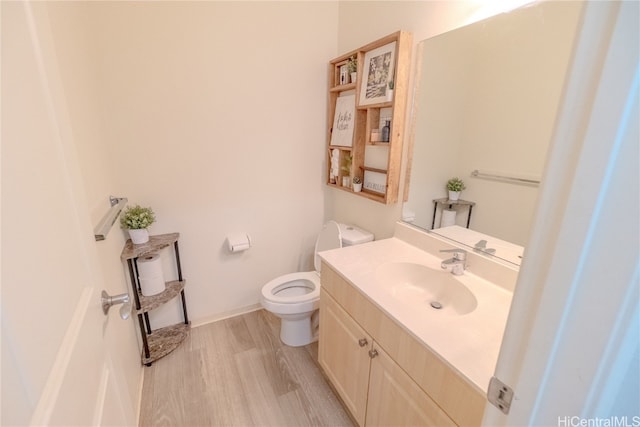 bathroom featuring vanity, toilet, and hardwood / wood-style flooring