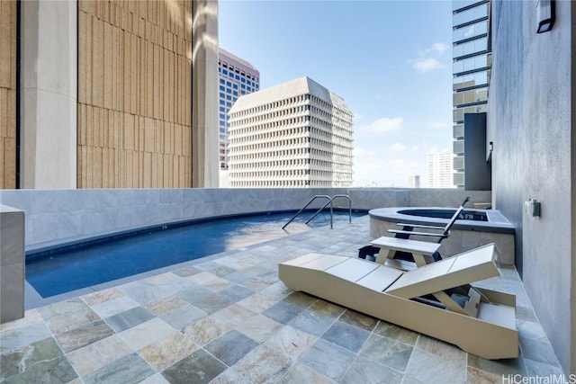 view of swimming pool with a hot tub