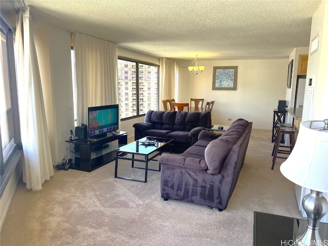 living room featuring a notable chandelier, a textured ceiling, and light colored carpet