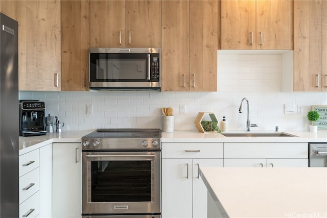 kitchen with white cabinets, sink, and appliances with stainless steel finishes