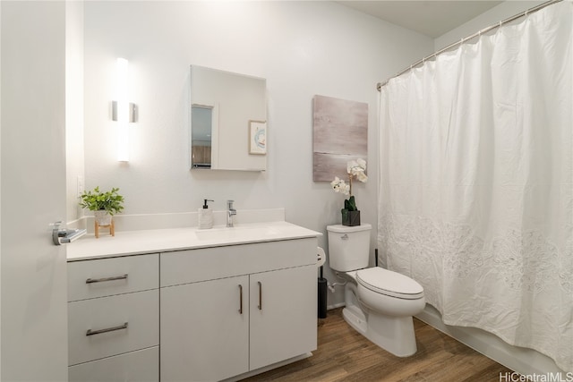 bathroom with curtained shower, toilet, vanity, and hardwood / wood-style flooring