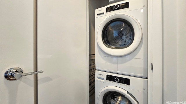 clothes washing area featuring stacked washer and clothes dryer