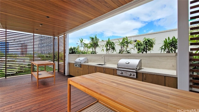 wooden terrace featuring exterior kitchen, sink, and a grill