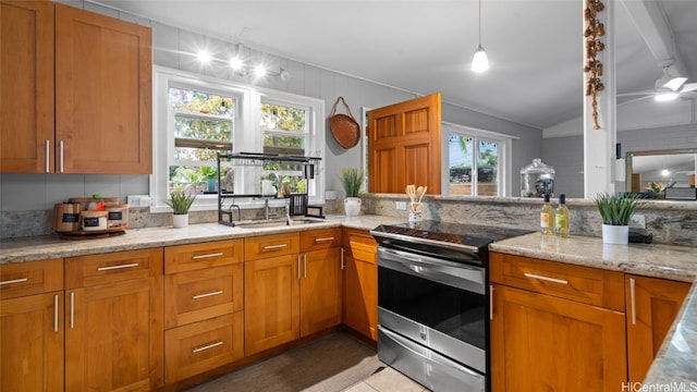 kitchen with a wealth of natural light, lofted ceiling, sink, and stainless steel electric stove