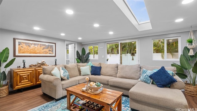 living room featuring a wealth of natural light, hardwood / wood-style floors, and a skylight