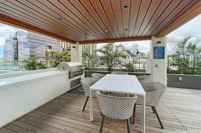 wooden terrace with an outdoor kitchen and grilling area