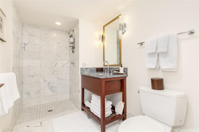 bathroom with tiled shower, vanity, and toilet