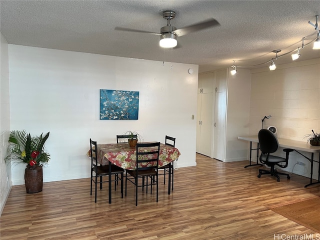 dining room featuring hardwood / wood-style floors, ceiling fan, and a textured ceiling