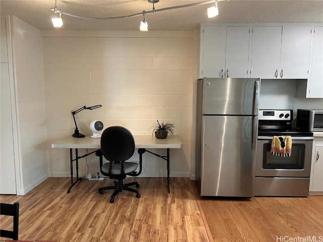 office space featuring a textured ceiling and light wood-type flooring