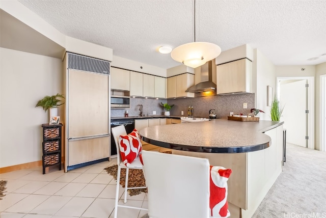 kitchen featuring wall chimney exhaust hood, a textured ceiling, white appliances, sink, and decorative light fixtures