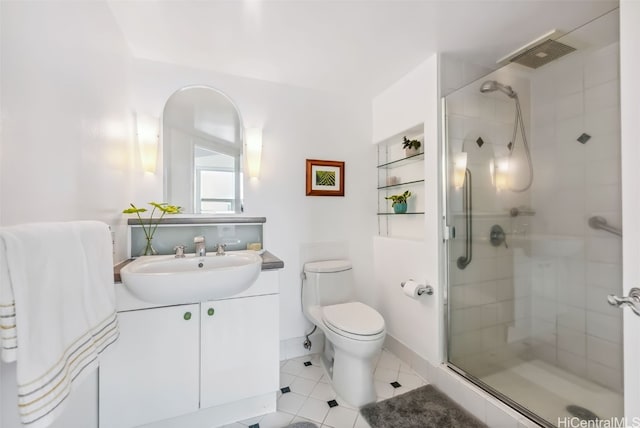 bathroom featuring tile patterned flooring, vanity, toilet, and walk in shower