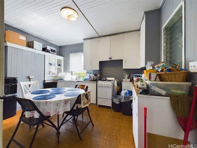 kitchen featuring white cabinets, dark parquet floors, and white gas range oven