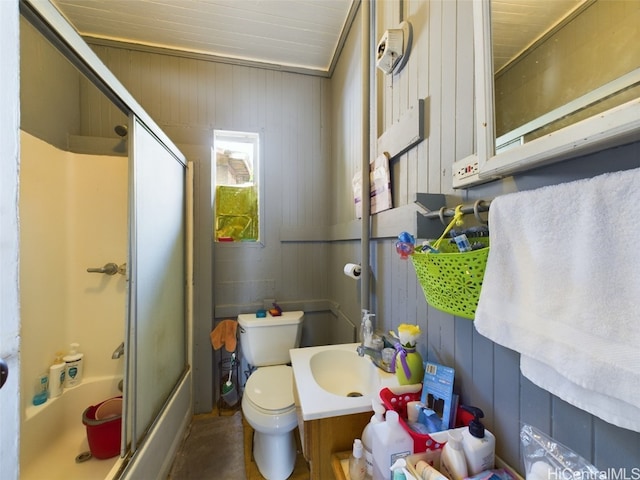 full bathroom with vanity, toilet, enclosed tub / shower combo, and wooden walls