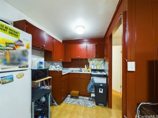 kitchen with tasteful backsplash, light parquet flooring, sink, and white refrigerator