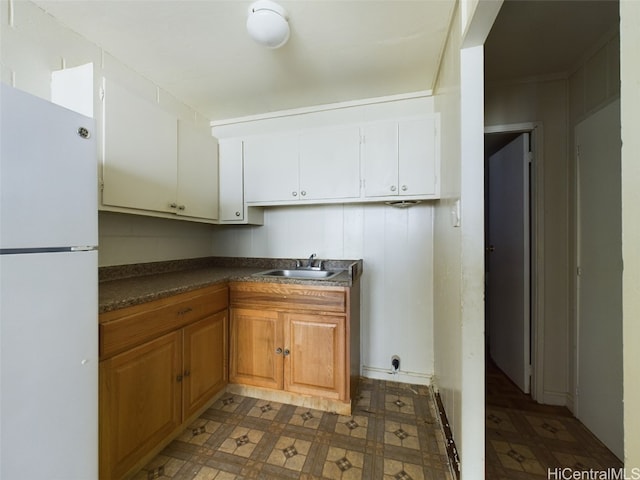 kitchen featuring white cabinetry, sink, and white refrigerator