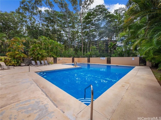 pool with a patio area and fence