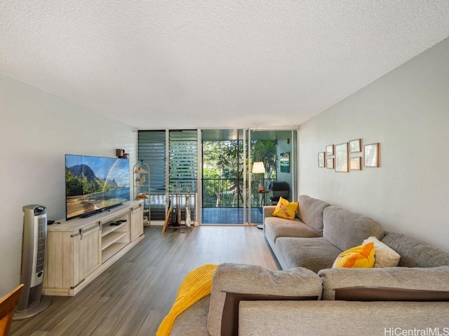 living room with a textured ceiling, wood finished floors, and floor to ceiling windows