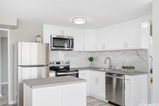 kitchen featuring white cabinetry, sink, light hardwood / wood-style flooring, and appliances with stainless steel finishes