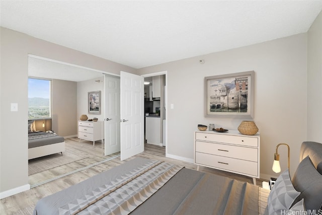 bedroom featuring a textured ceiling and light hardwood / wood-style floors