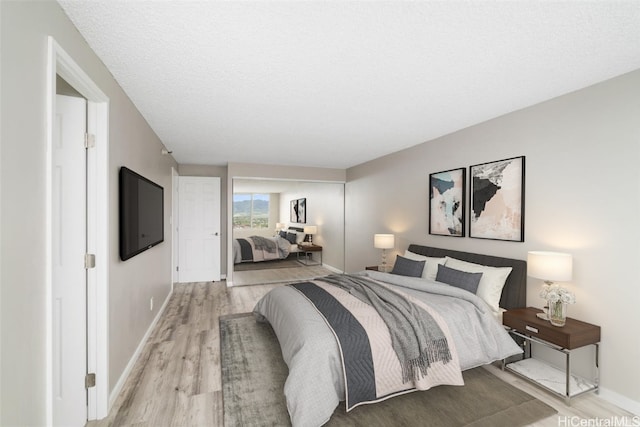 bedroom with light hardwood / wood-style floors and a textured ceiling