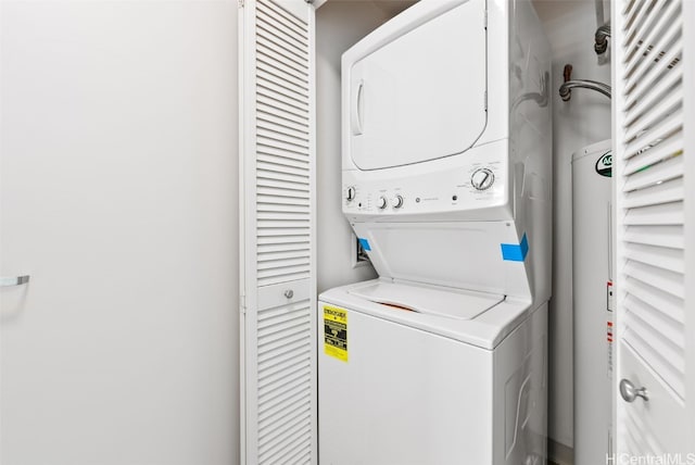 laundry area featuring water heater and stacked washer and clothes dryer