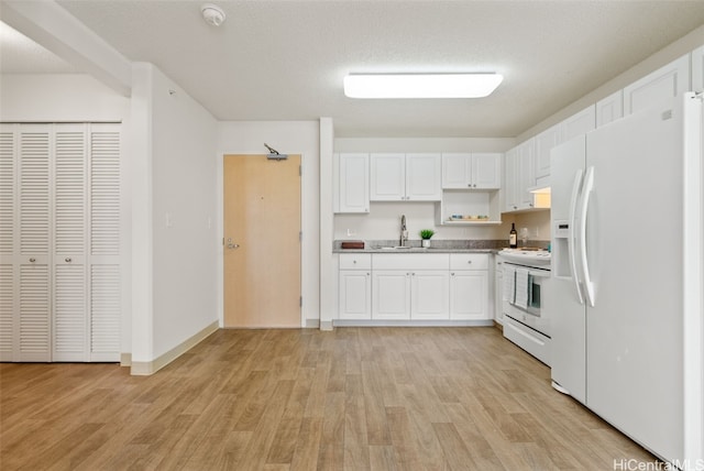 kitchen featuring sink, white cabinets, light hardwood / wood-style flooring, and white appliances