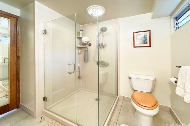 bathroom featuring toilet, tile patterned floors, and a shower with door