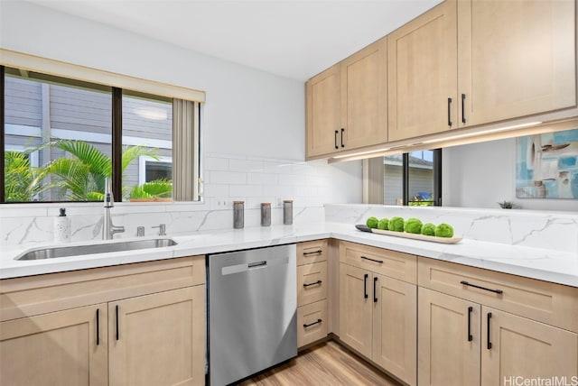 kitchen with light brown cabinets, stainless steel dishwasher, sink, and plenty of natural light