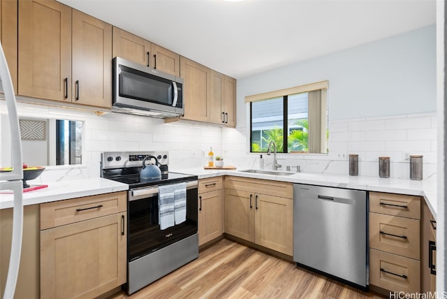 kitchen featuring light hardwood / wood-style flooring, stainless steel appliances, backsplash, sink, and light brown cabinetry