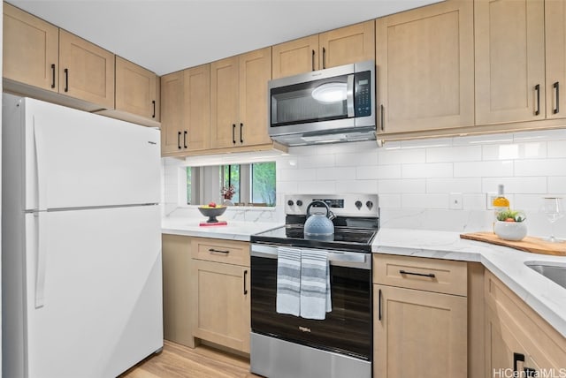 kitchen featuring appliances with stainless steel finishes, light hardwood / wood-style flooring, and light brown cabinetry