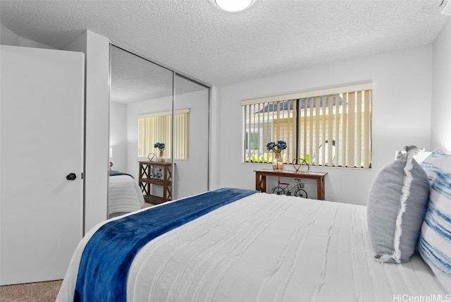 carpeted bedroom featuring a textured ceiling and a closet